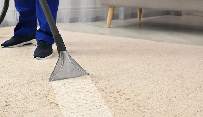 man cleaning carpet with professional vacuum cleaner
